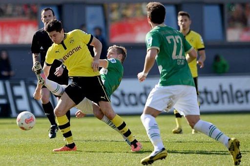 Dortmund's Robert Lewandowski (L) and Fuerth's Johannes Geis (C) fight for the ball in Fuerth, April 13, 2013